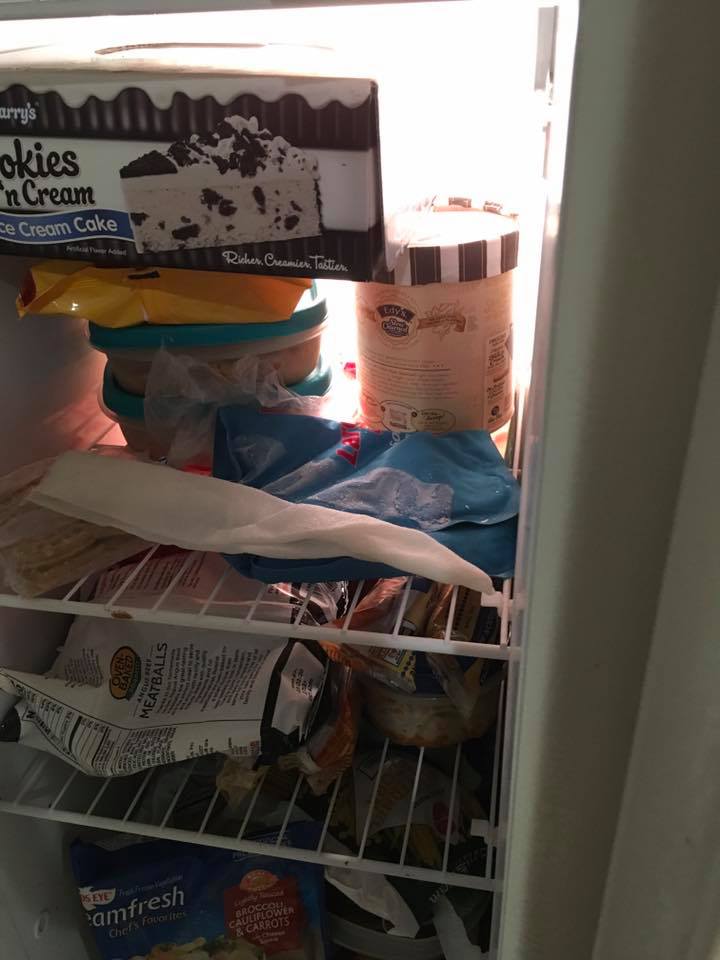 A freezer shelf with a frozen paper towel stretched across food packages.