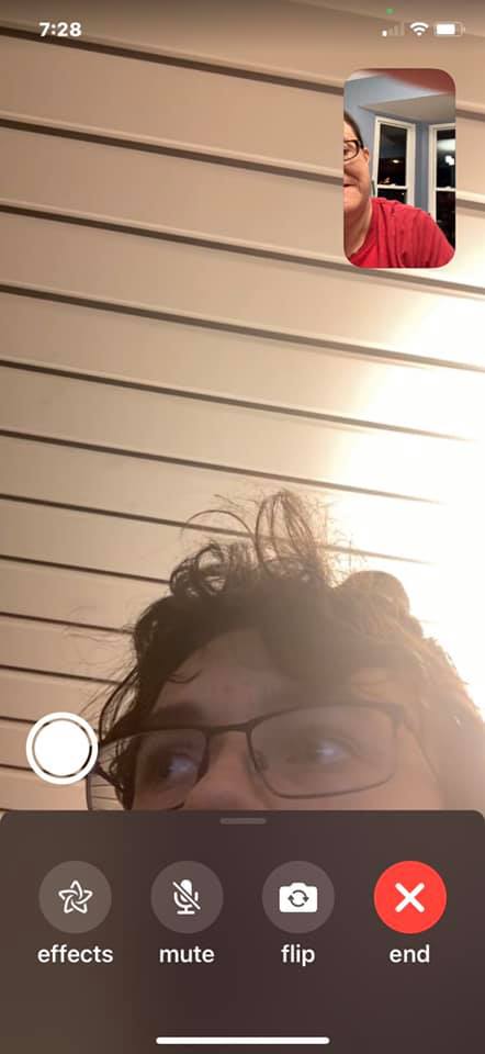 A FaceTime screenshot showing mostly ceiling, with a person’s forehead and glasses at the bottom and another person in the small call window.