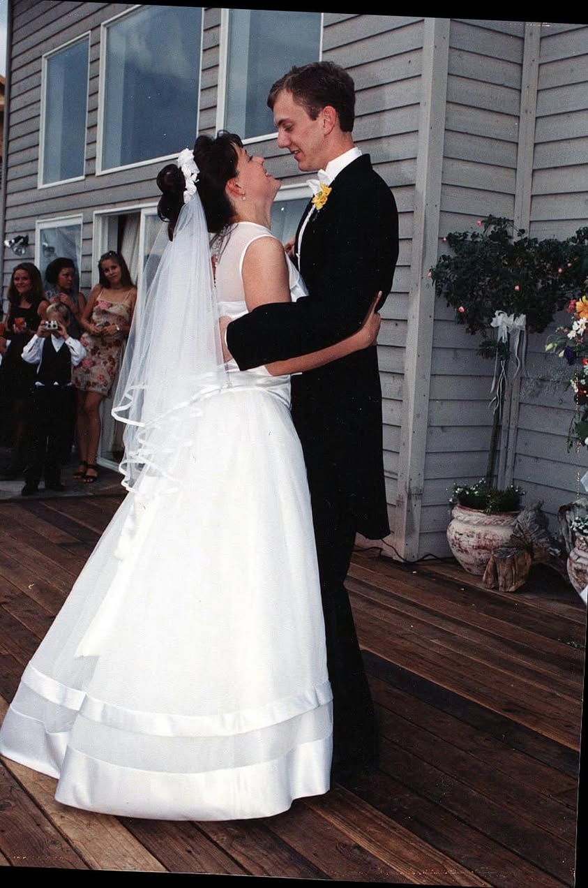 Bride and groom embracing outdoors during their wedding celebration.