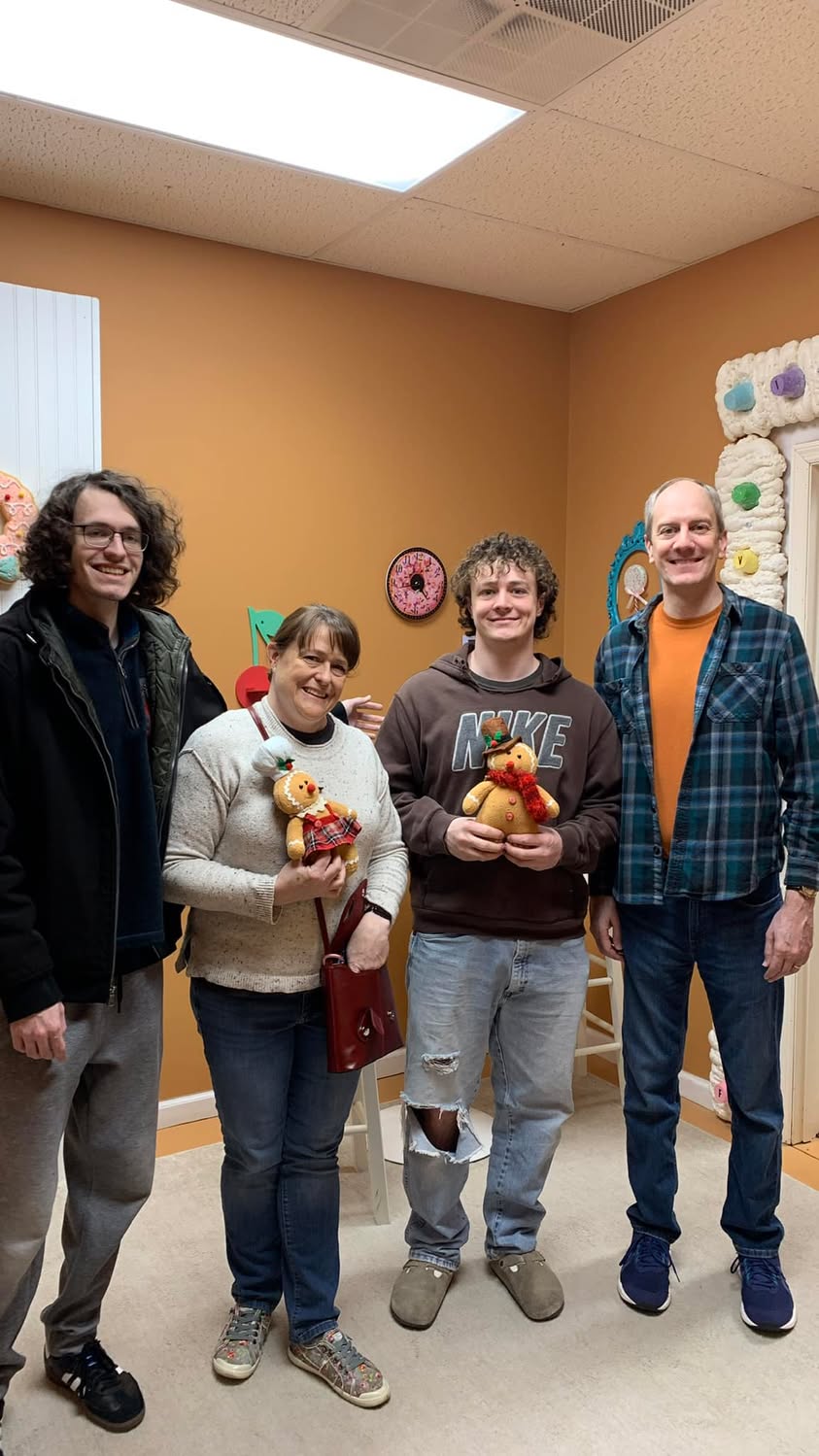 Four family members posing together after completing an escape room.
